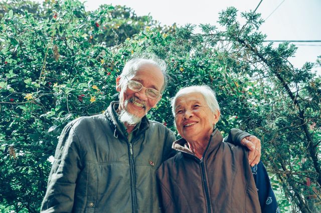 Pareja de adultos mayores sonriendo en un jardín